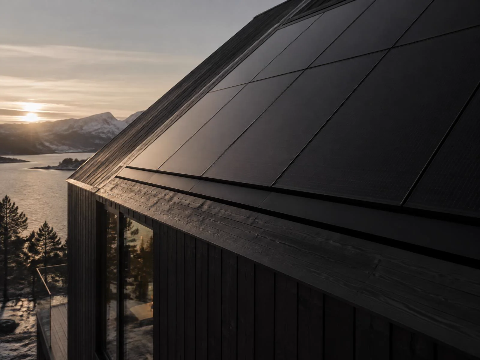 Helsvarta solpaneler på ett mörkt träklätt hus en frostig morgon